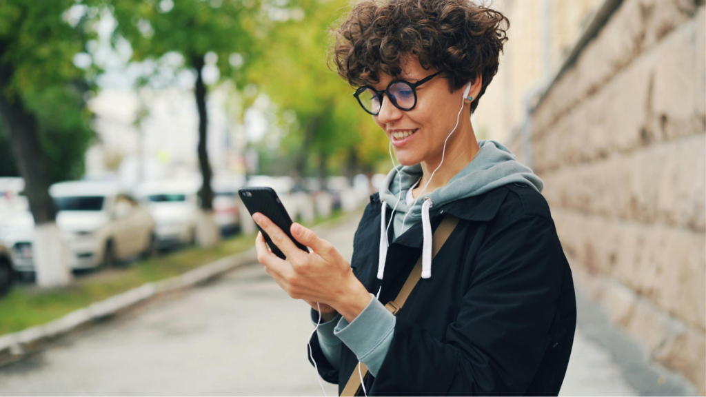 Jovem aprendendo francês na rua com fones de ouvido