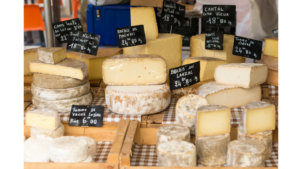 Queijos franceses expostos em mercado, símbolo do prazer de aprender francês na vida real"